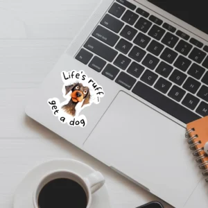 A laptop featuring a sticker on the bottom left corner - the sticker features a comical dog illustration with the text 'Life's Ruff - Get a Dog'